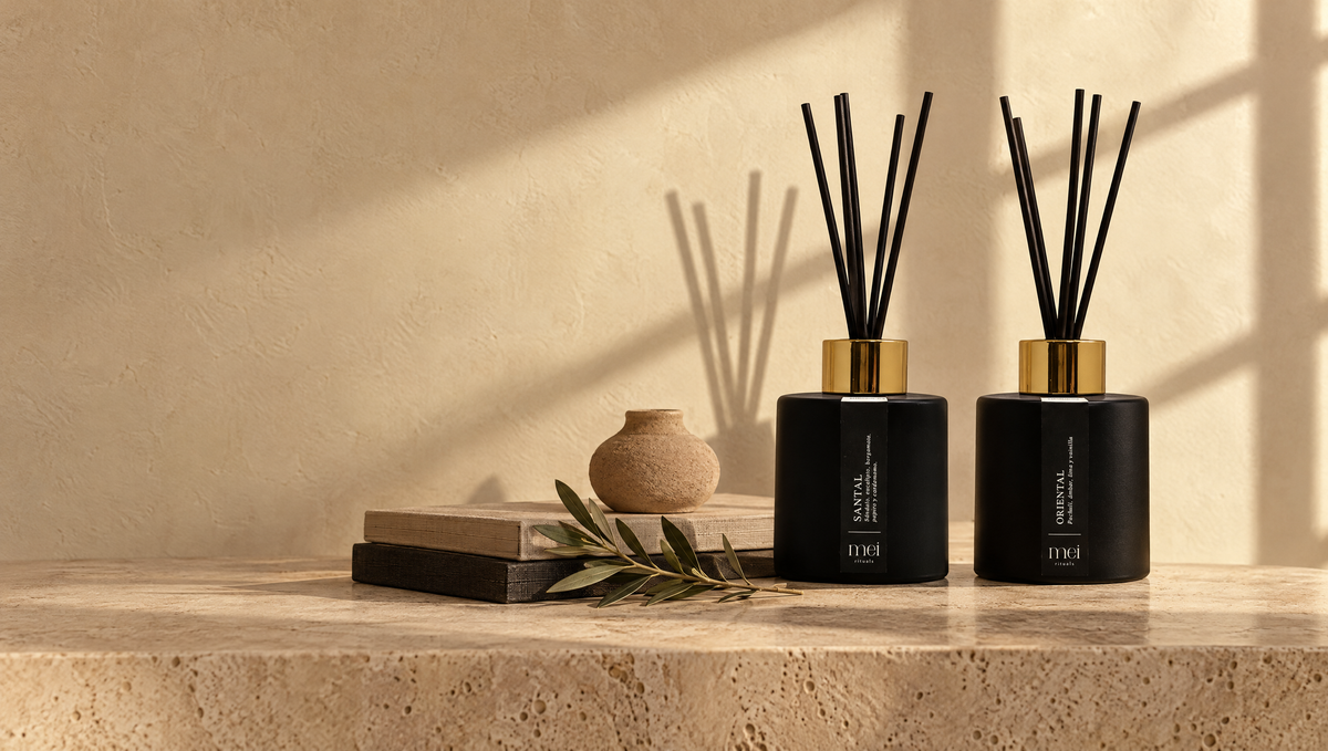 Difusores de varillas Santal y Oriental de Mei Rituals sobre una consola de travertino con luz de tarde, guía de difusores de varillas